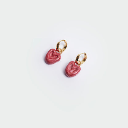 Aretes colgantes estilo hoops en fondo blanco y forma de corazón en color rojo y en material de cerámica con candongas en acero inoxidable en color dorado