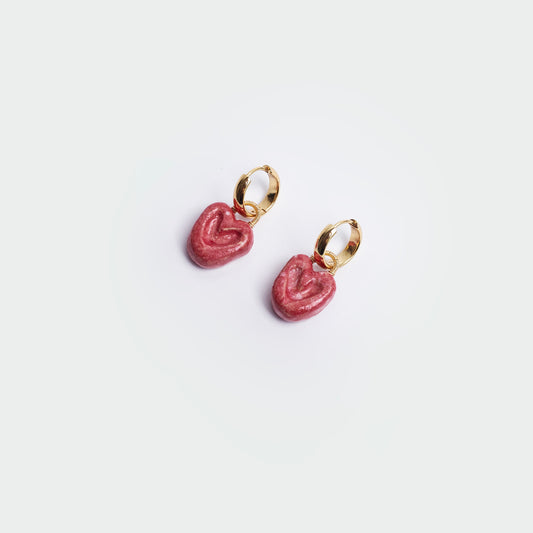 Aretes colgantes estilo hoops en fondo blanco y forma de corazón en color rojo y en material de cerámica con candongas en acero inoxidable en color dorado