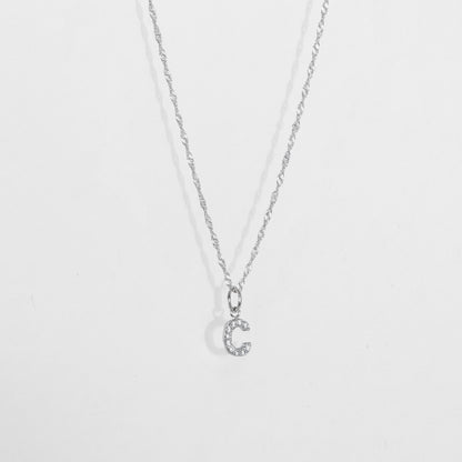 Cadena en material de plata ley 925 en tejido eslabón fino con dije de letra C con diamantes zircones incrustados.