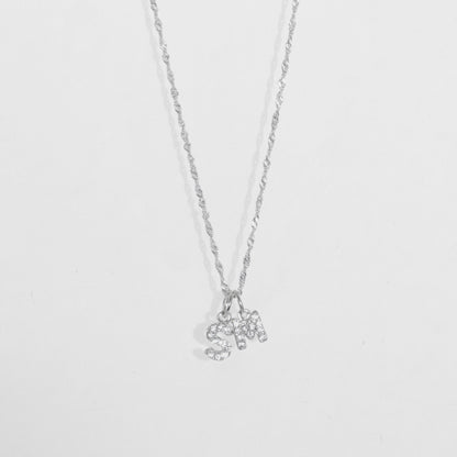 Cadena en material de plata ley 925 en tejido eslabón fino con dije doble con letras S y M con diamantes zircones.