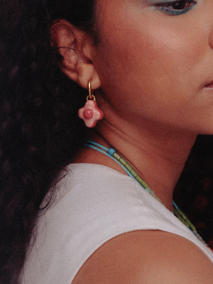 Imagen frontal de modelo de tés morena y cabello ondulado utilizando un vestido blanco y negro, y hoops Peonías frambuesa de chouette 